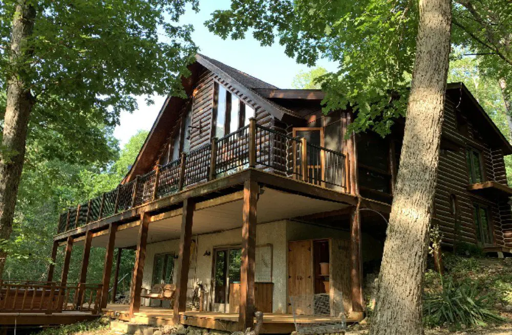 A large wooden house with a porch and balcony.