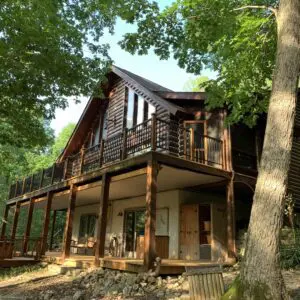 A large log house with a porch and balcony.