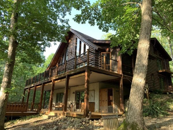 A large log house with a porch and balcony.