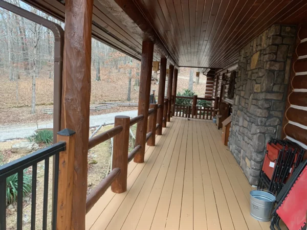 A porch with wooden railings and stone walls.