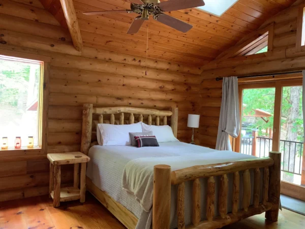 A bedroom with wood paneled walls and ceiling.