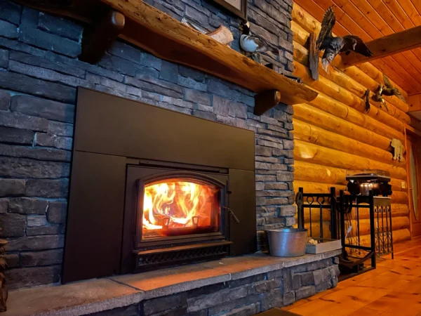 A fireplace with logs and wood burning in it.