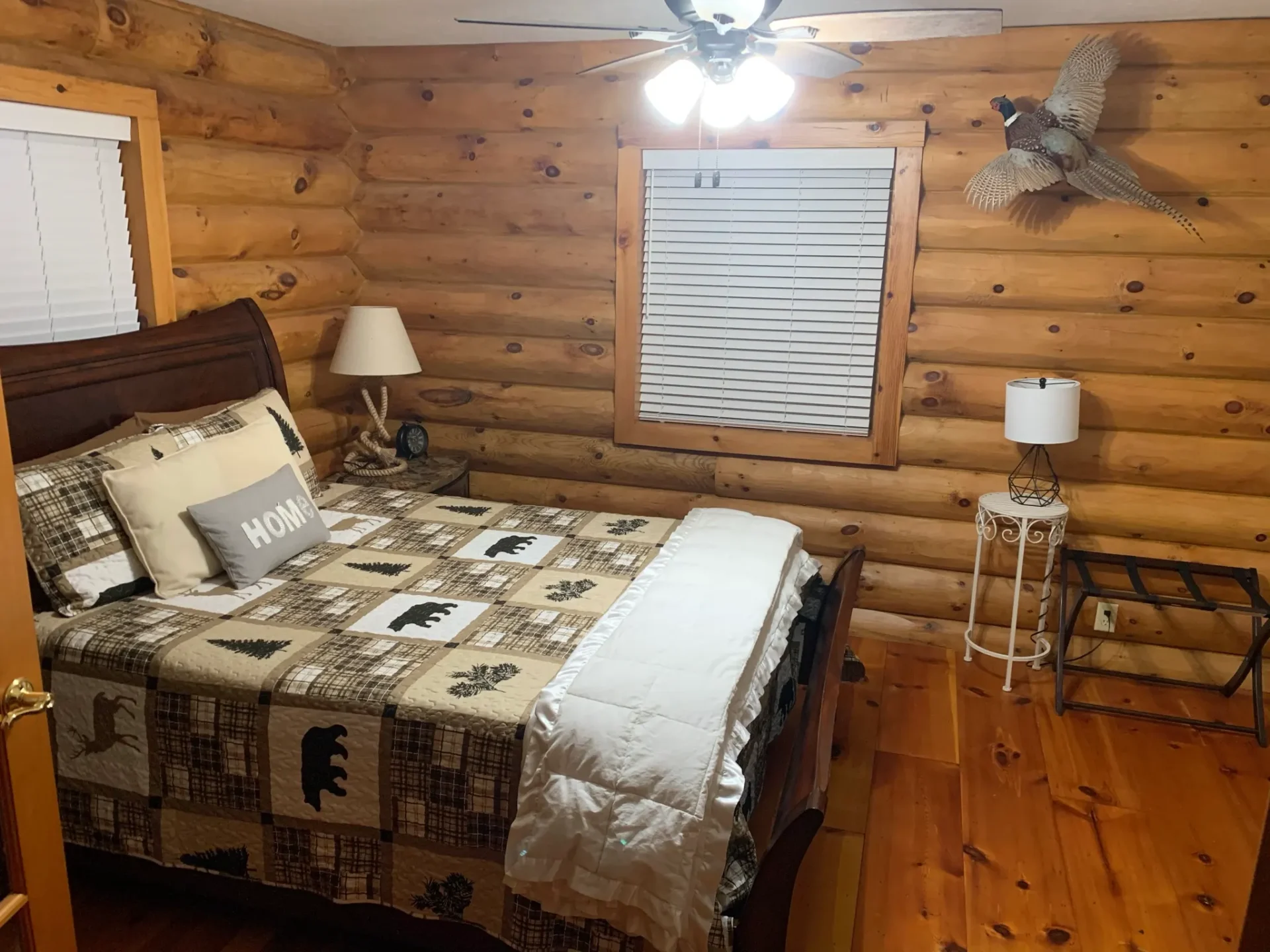 A bedroom with a bed, nightstand and window.