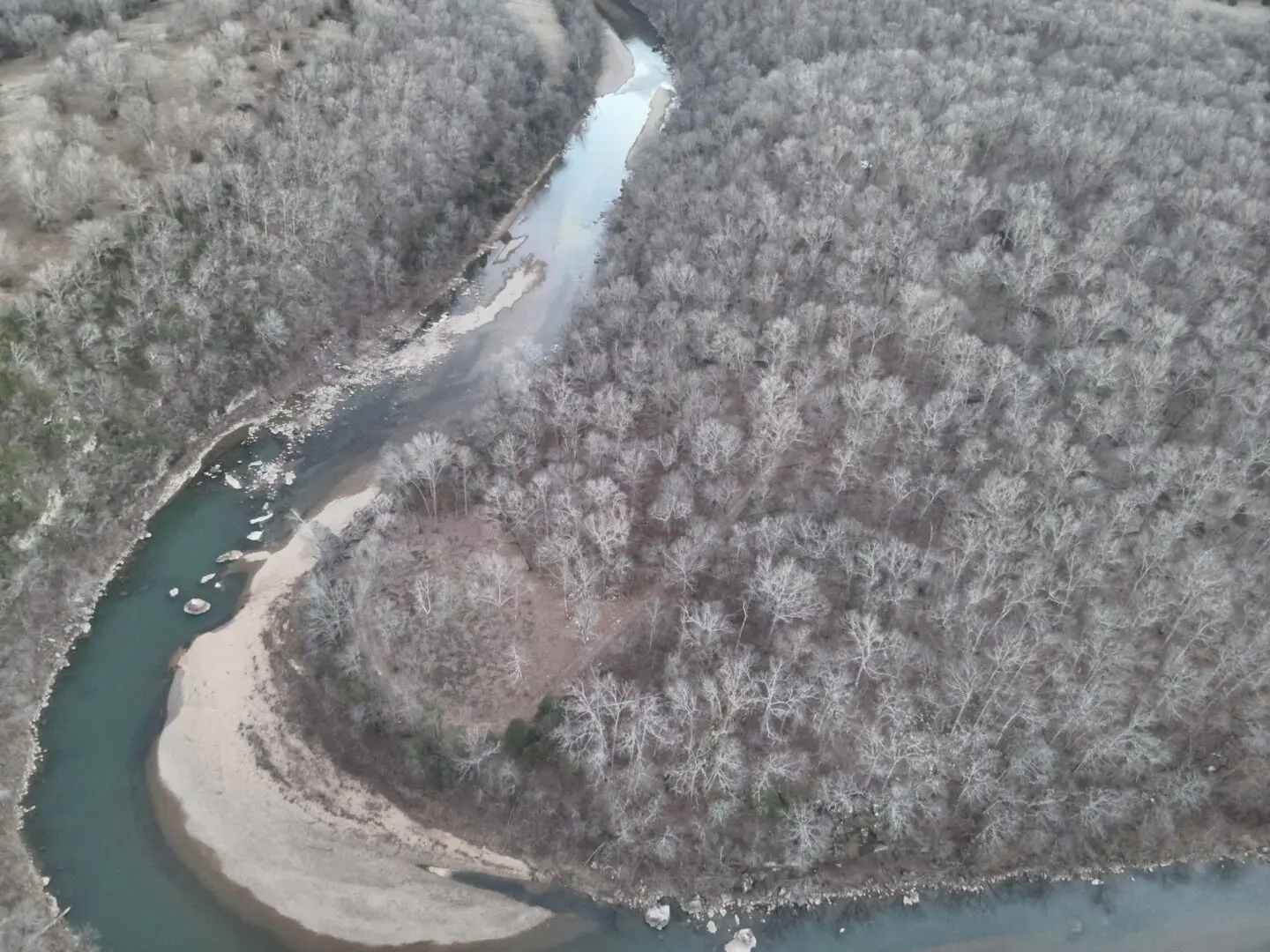 A river with snow on it's banks and trees.