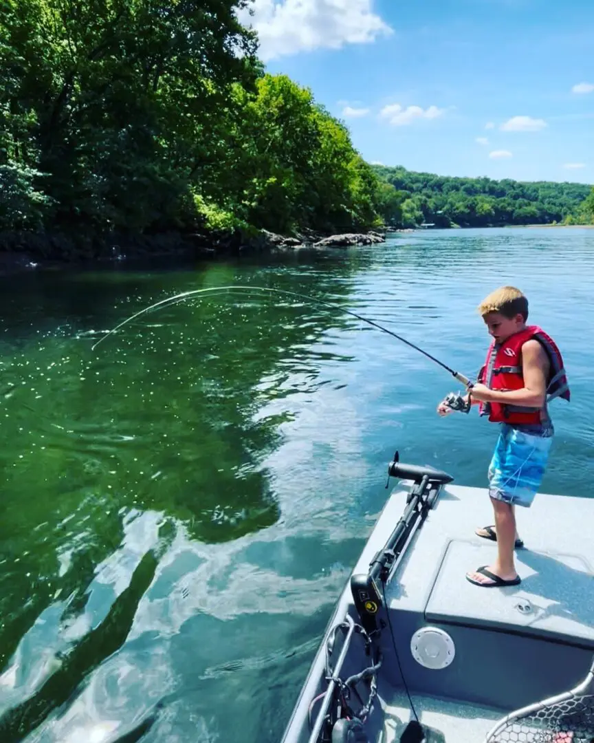 A boy is fishing on the water