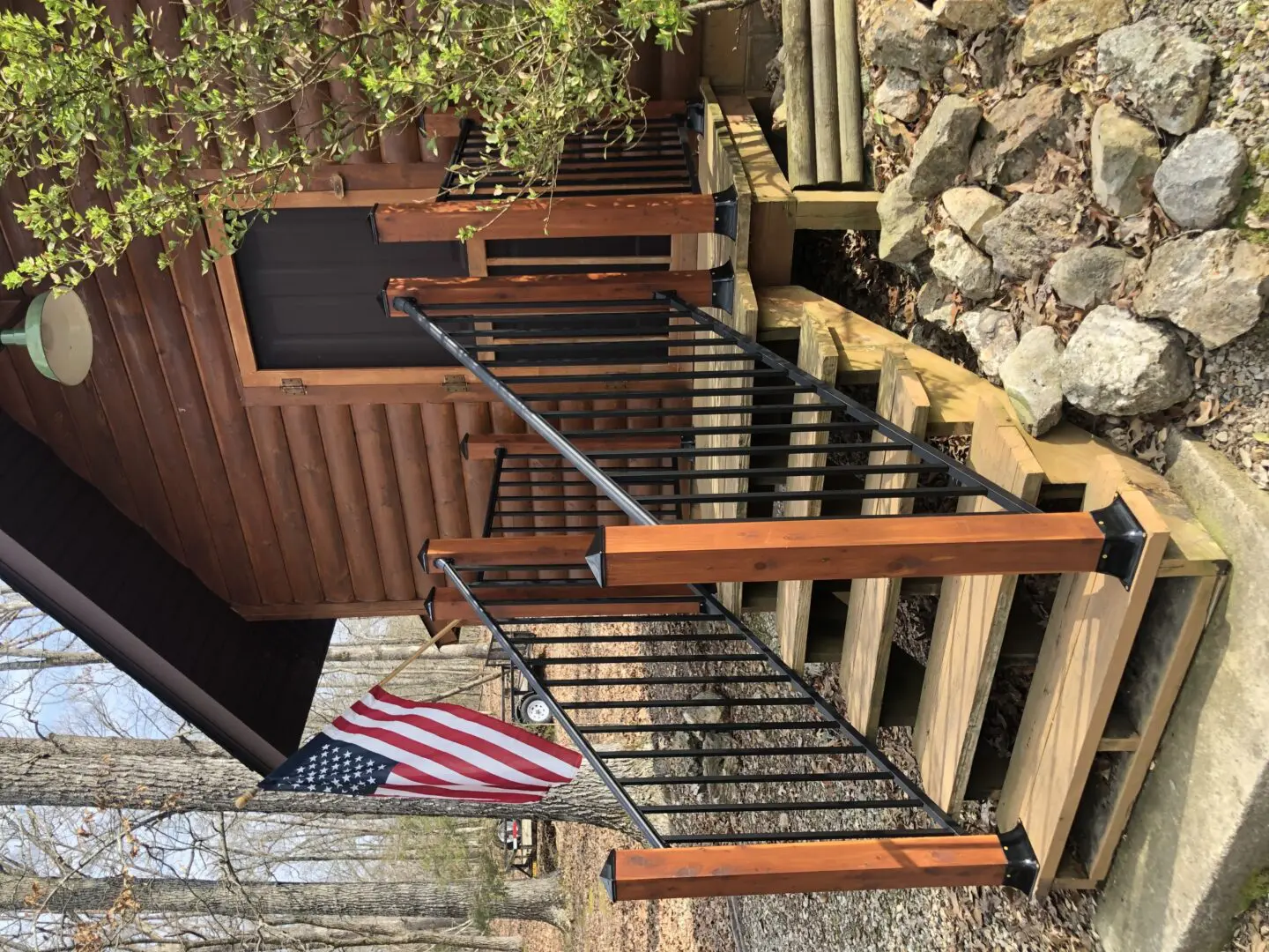 A wooden staircase with metal railing and american flag.