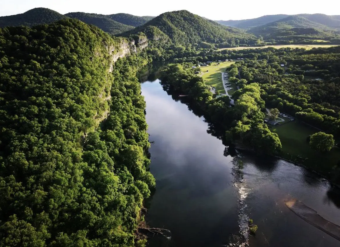 A river with trees on it and mountains in the background