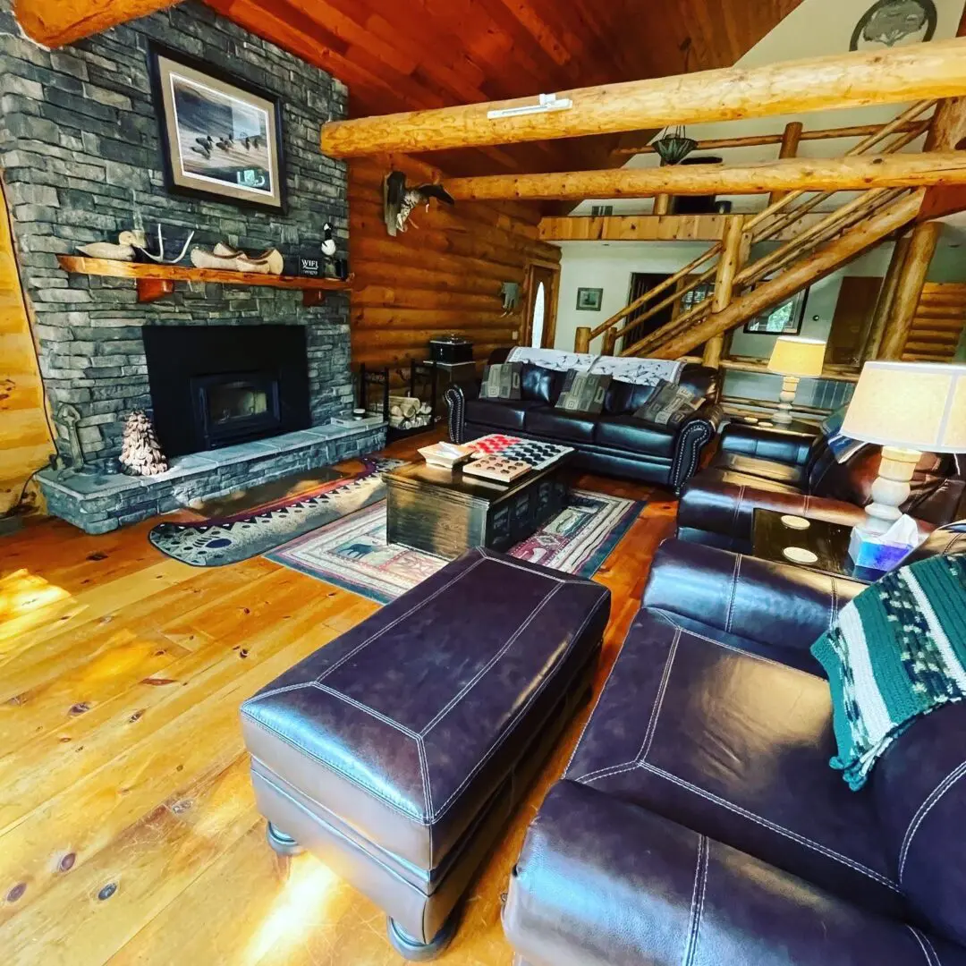 A living room with leather furniture and wood floors.